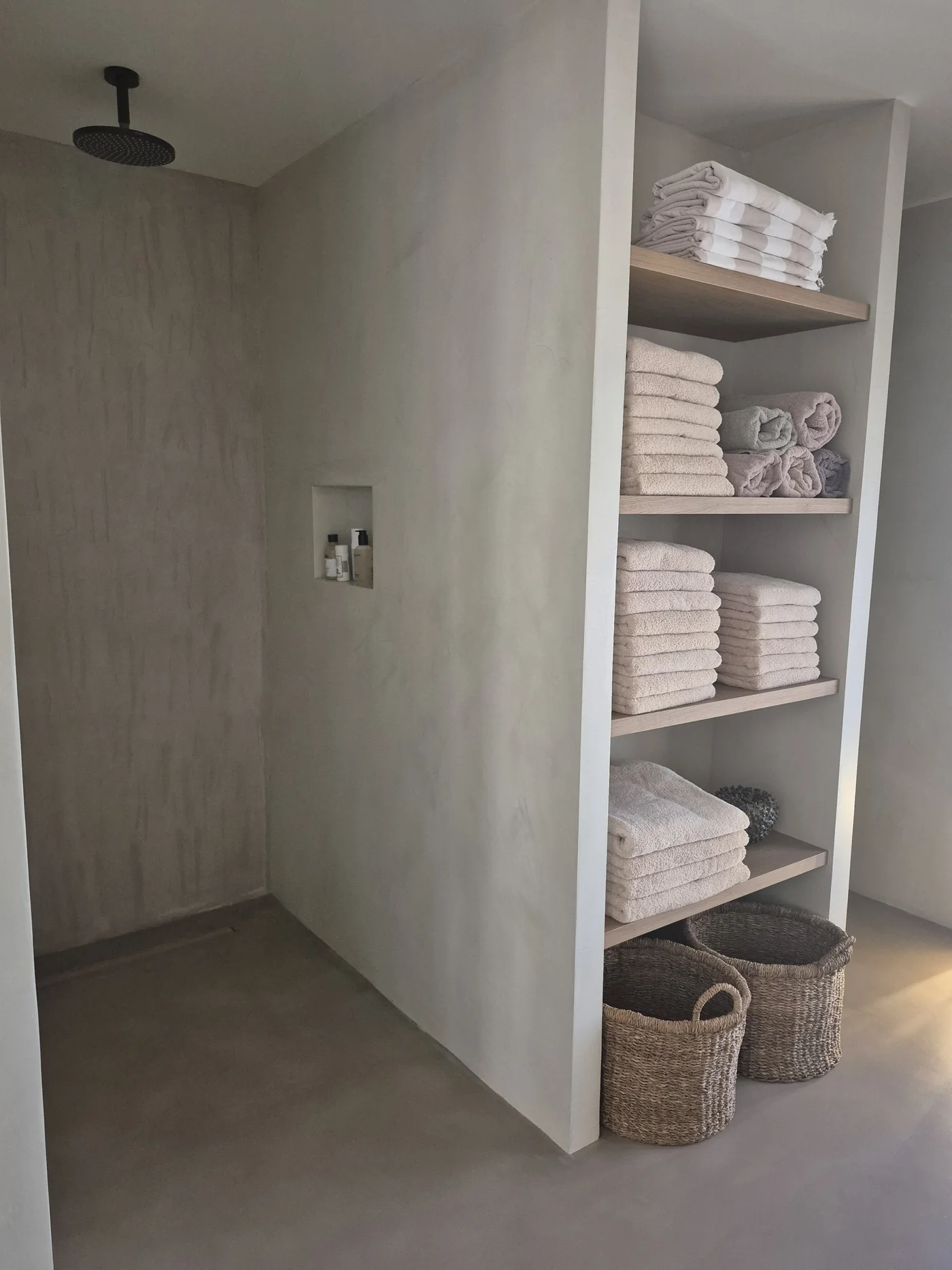 Ducha de obra en microcemento con hornacina integrada y estantería de roble — La Cumbre